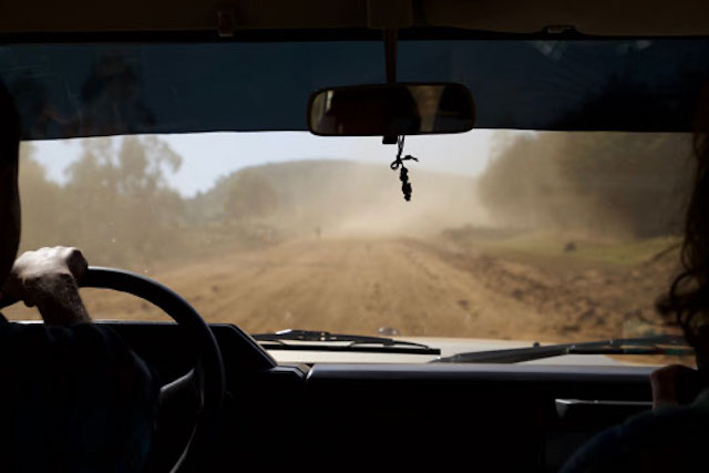 A can drives down a dirt road in rural Ethiopia 