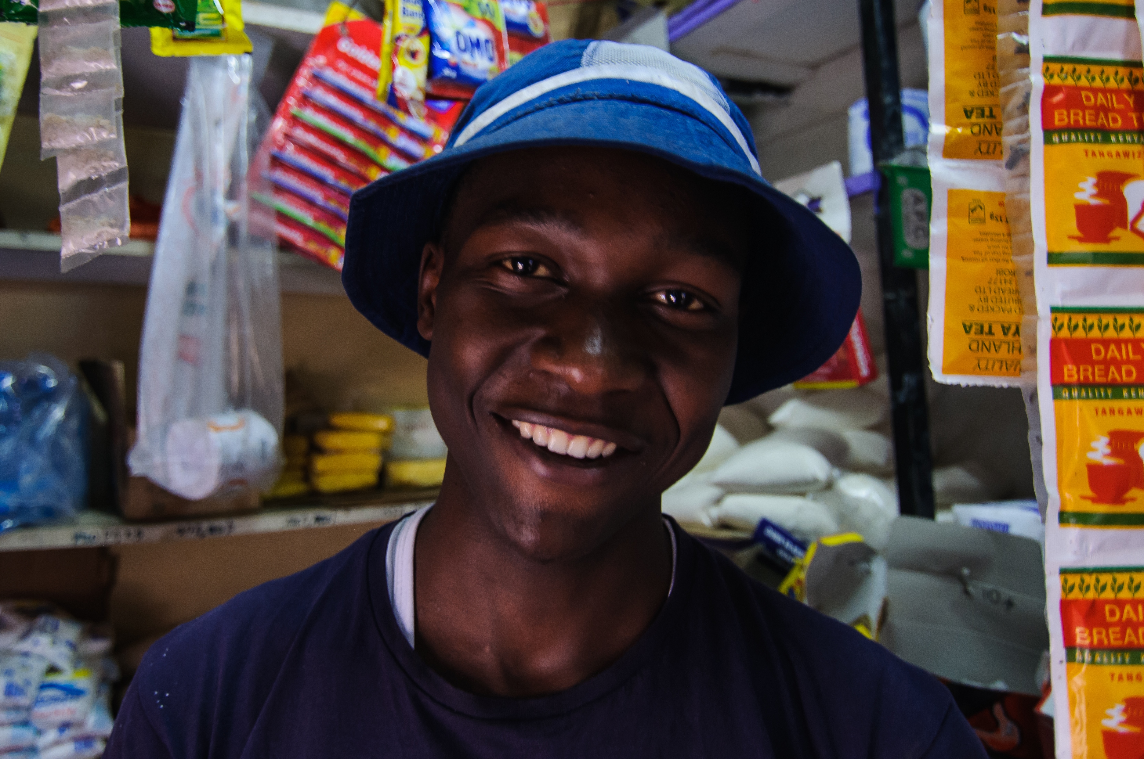 Cosmas Mwangi standing at his shop window in Nairobi