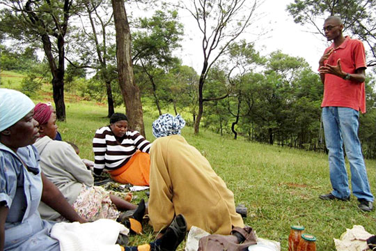 TechnoServe business advisor Musa Maseko teaching financial literacy training to a group of Swazi women