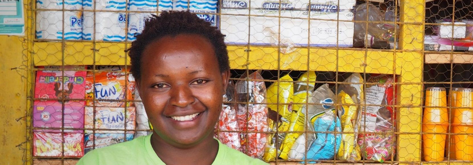 Woman smiling in front of food in Kenya