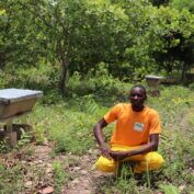 Baranon sits on a mat with his three children in Benin. (TechnoServe) Part of a blog post to support fathers on Father's Day.