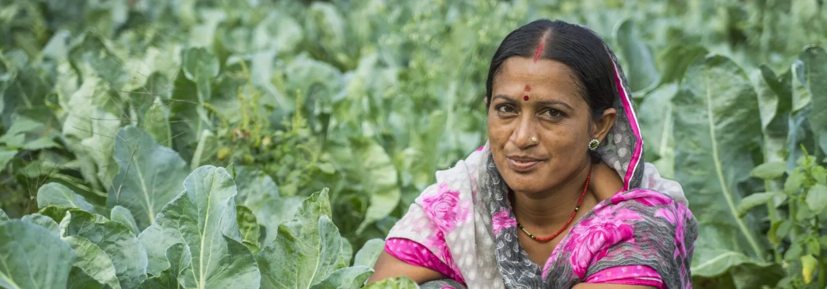 A woman poses with her crops in India. Part of an Earth Day quiz.