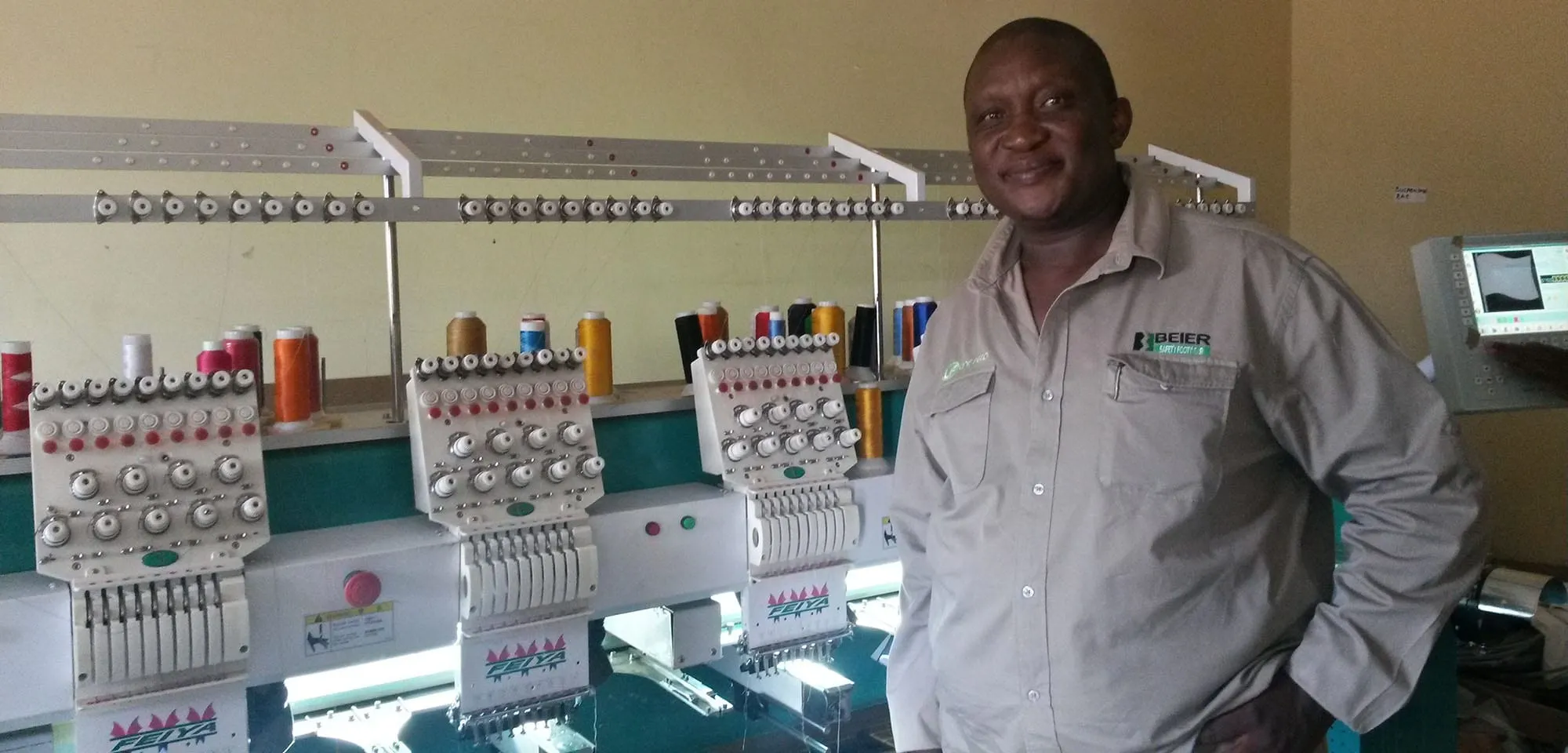 Man smiling working in a sewing shop in Botswana