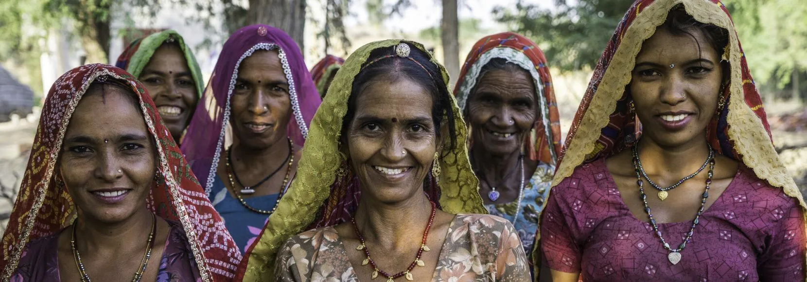 A group of women who are a part of Technoserve's kitchen garden program, pose for a group portrait in a kitchen garden in Bamanwali village, Bikaner, Rajasthan, India on October 24th, 2016. Non-profit organisation Technoserve works with farmer's wives in Bikaner, providing technical support and training for edible gardening, to improve the nutritional quality of their food and relieve financial stress on farming communities. Photograph by Suzanne Lee for Technoserve