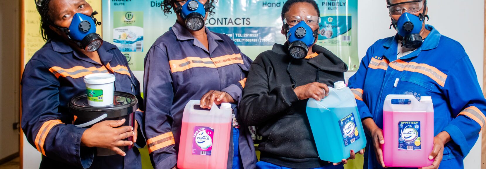 Four women stand with their products in Botswana. Part of a blog post on empowering women.