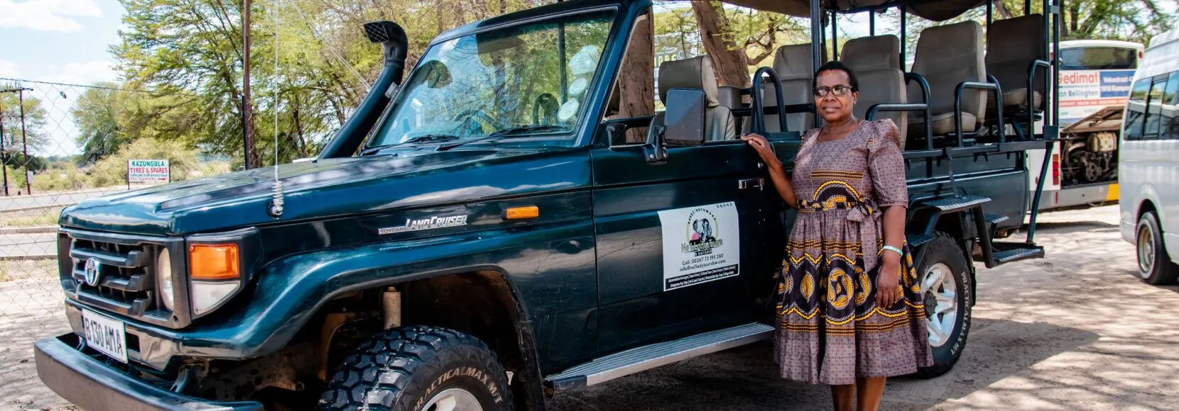 A woman stands next to her safari vehicle in Botswana.