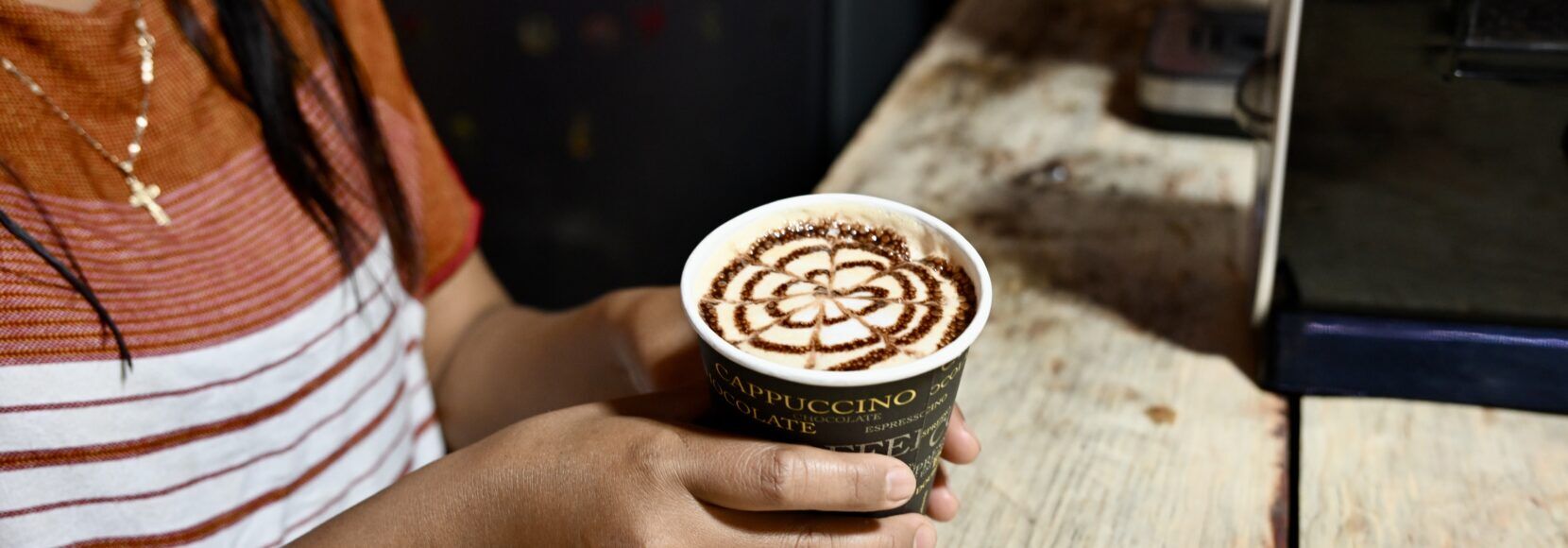 A woman pours a latte in a small coffee shop in Guatemala on National Coffee Day