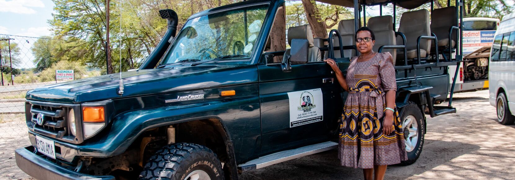 A woman stands next to her safari vehicle in Botswana.