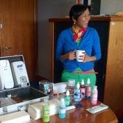 Woman smiling with set of sanitization soaps on table