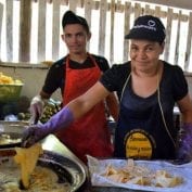 Two people helping process food and cook