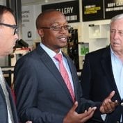 Three business men smiling and talking