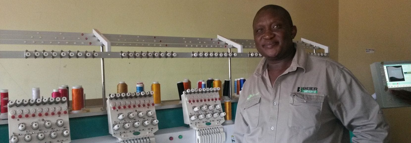 Man smiling working in a sewing shop in Botswana