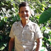 Man smiling in front of plants