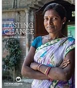 Indian woman smiling in front of home