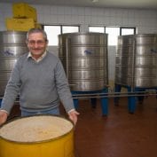 Man smiling in Chile with bin of grain