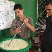 Two smallholder dairy farmers working together