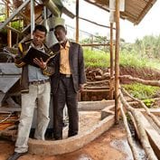 Two men working while inspecting a book