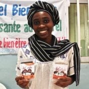 Woman smiling holding bags of coffee