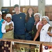 Group of people smiling holding cocoa bags