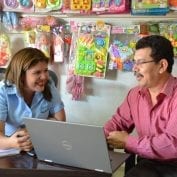 Small business owners smiling while looking at computer