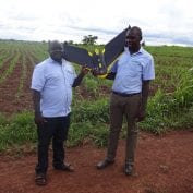 two men smiling while flying drone