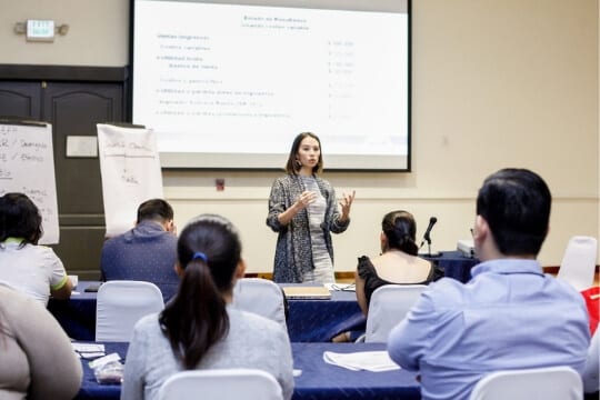 Woman teaching to a room full of people