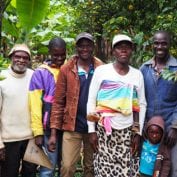 Family smiling surrounded by coffee trees