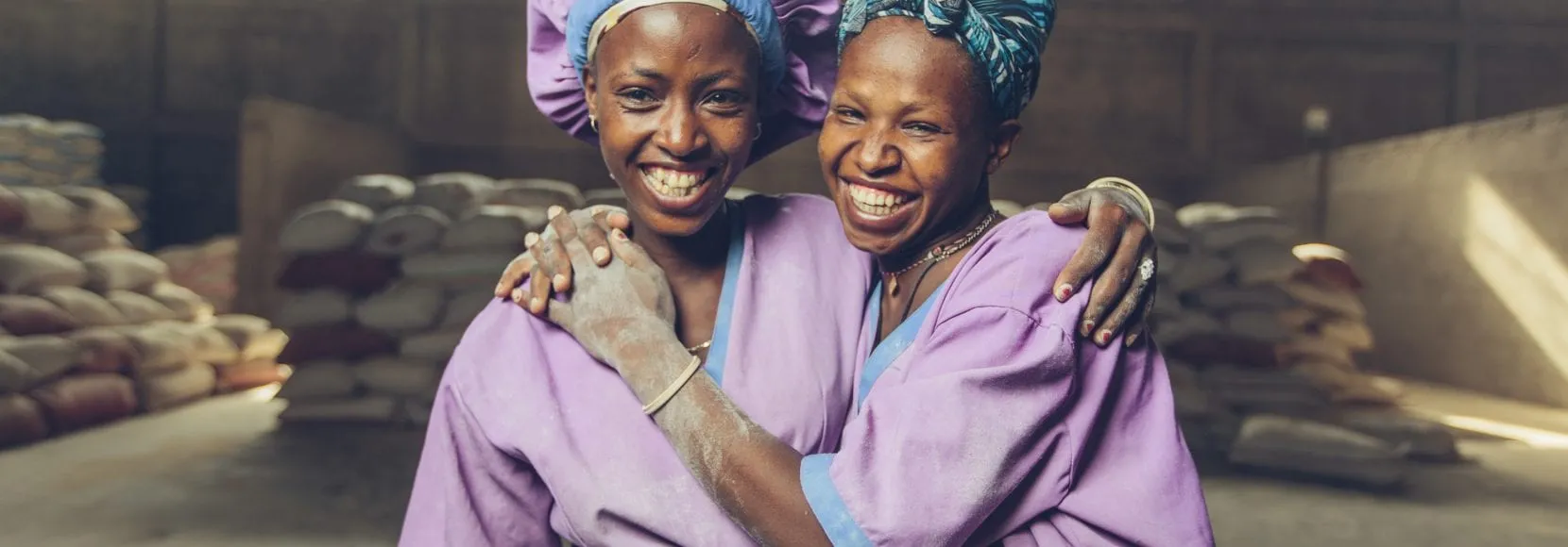 Women workers smiling at a grain mill in Sannie, Ethiopia
