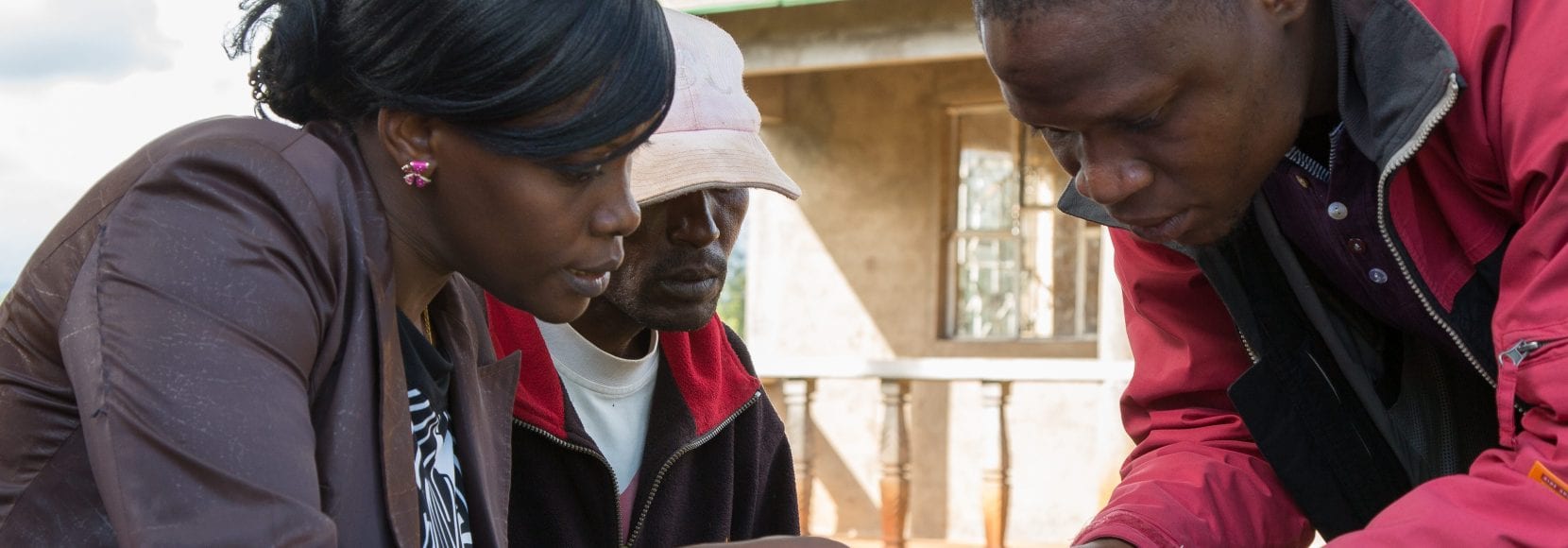 Farmers in Tanzania working with a consultant on record-keeping.
