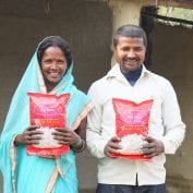 Smiling couple holding food up