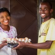 Two smiling people exchanging eggs