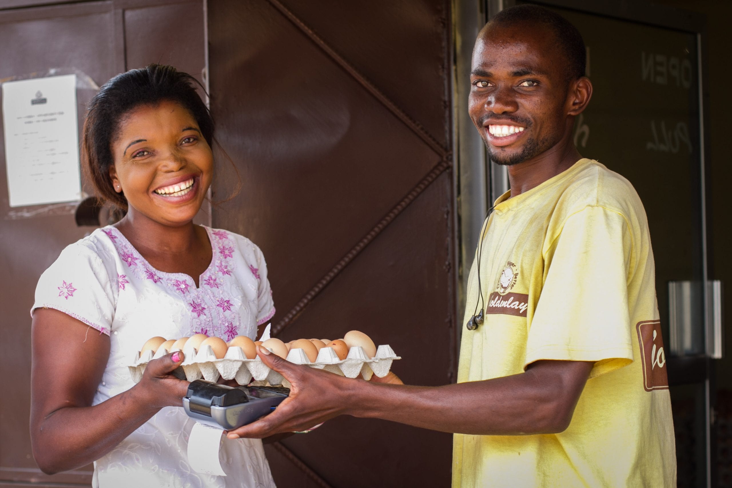 Two smiling people exchanging eggs