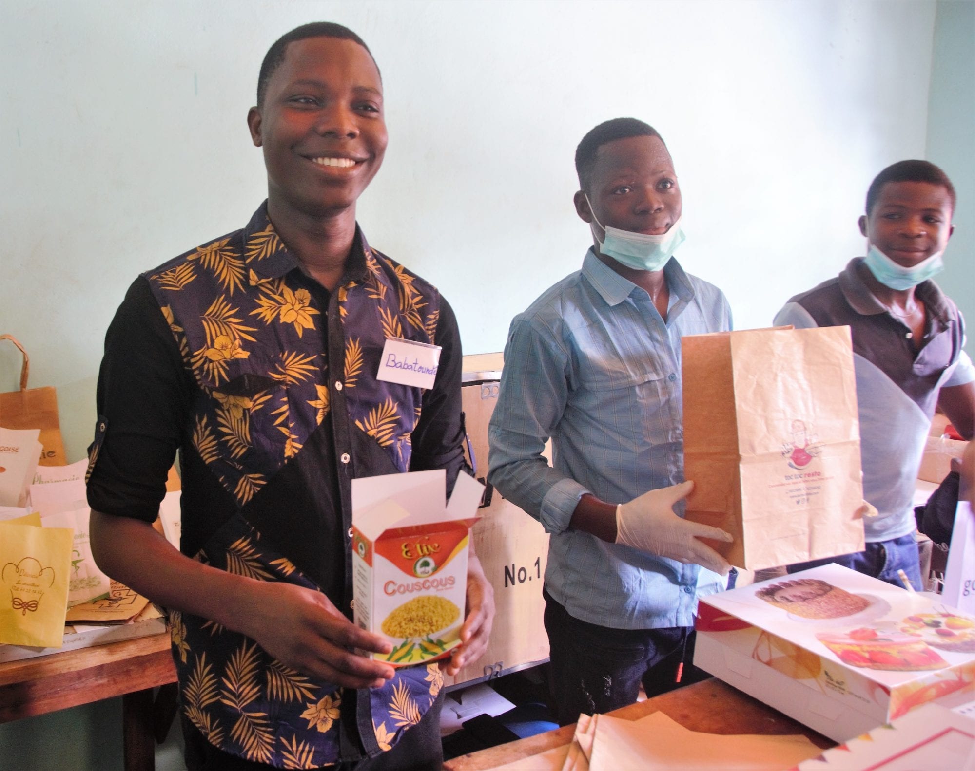 Babatundé Oguidi stands with his colleagues inside his packaging business in Benin 