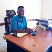 Smiling young man sitting behind a desk