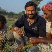 Smiling people inspecting crops