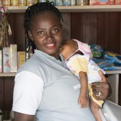 Woman working while holding sleeping baby