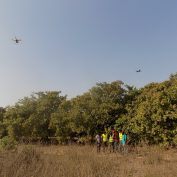 Drones fly over a field in Benin