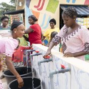 A group of women, all impacted by unpaid care work in their own way, gather water in Nigeria