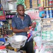 youth-owned shops open new doors for young people like Emanuel Barosha Ndiwene organizes products in his small shop in Dar es Salaam, Tanzania