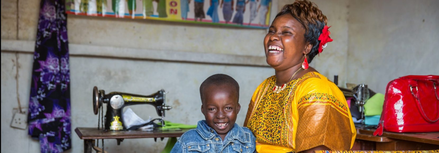 Human-centered design can power incredible solutions for international development. A woman holds a mobile phone near a sewing machine -