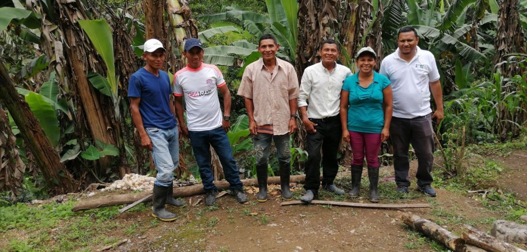 A group of farmers from Subirana who have learned ecologically sustainable techniques in a TechnoServe program stand with their crops