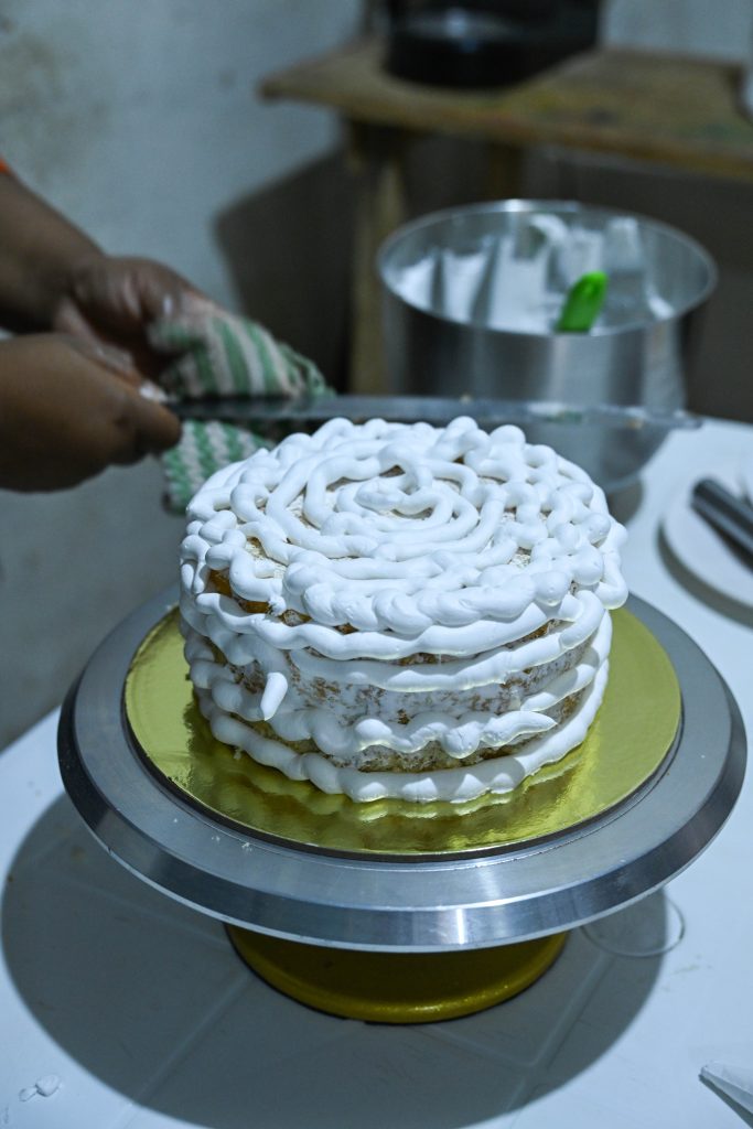 A partially decorated cake sitting on a table.