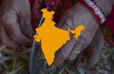 Hands working with a knife, with an outline of the Indian subcontinent superimposed on the image.