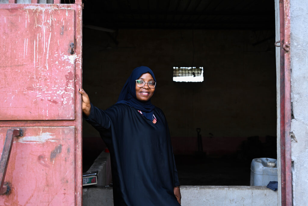 Rábia Eusebio, a young entrepreneur, stands before her poultry business in Nampula, Mozambique. Part of a blog post sharing youth success stories.