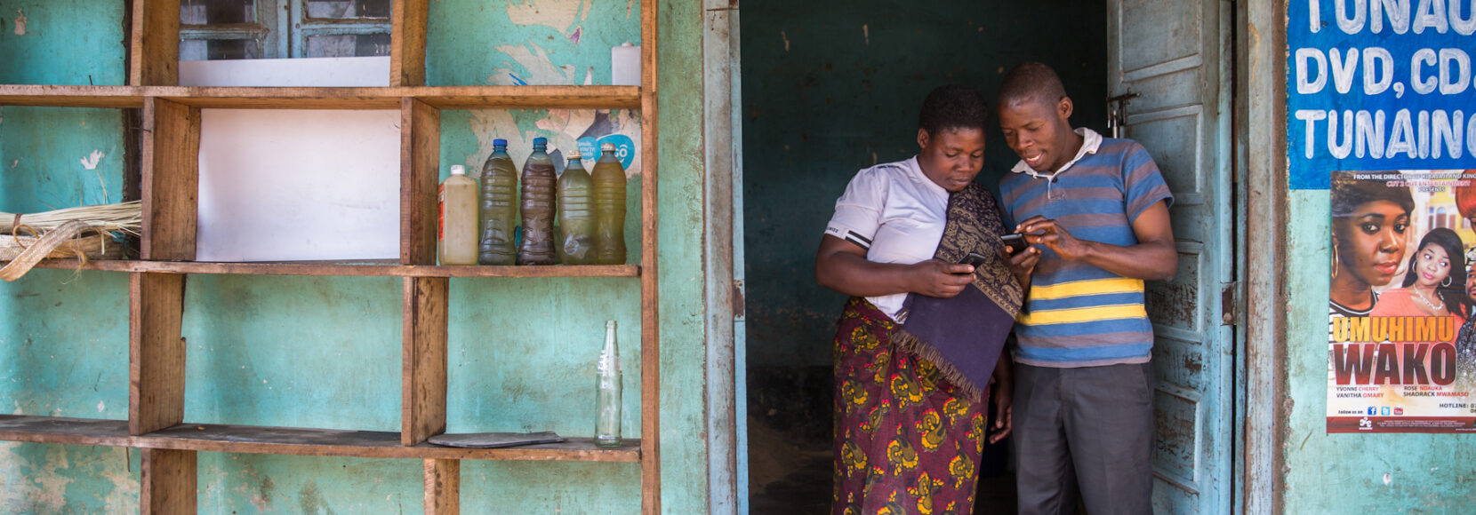 Two people standing in front of a shop in Kenya. Part of a blog post on AI in small business.