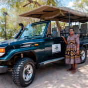 A woman stands next to her safari vehicle in Botswana.