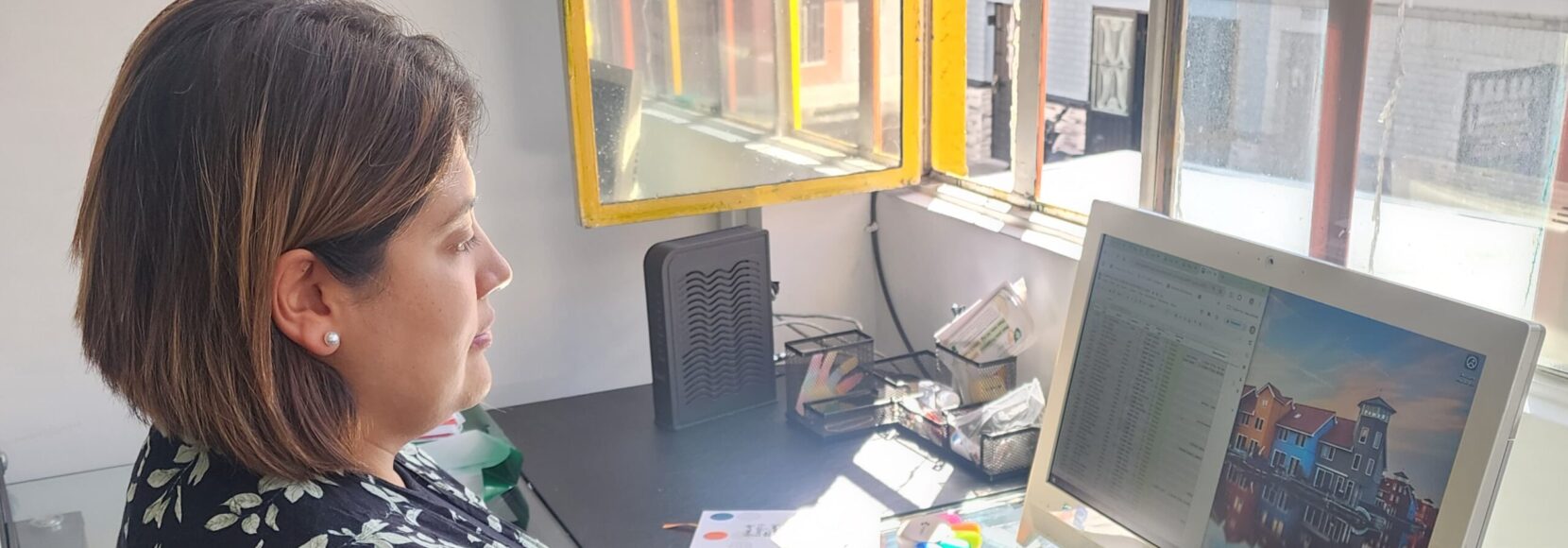 A woman sits at a computer in Colombia. Part of a blog post sharing young entrepreneurs' stories.