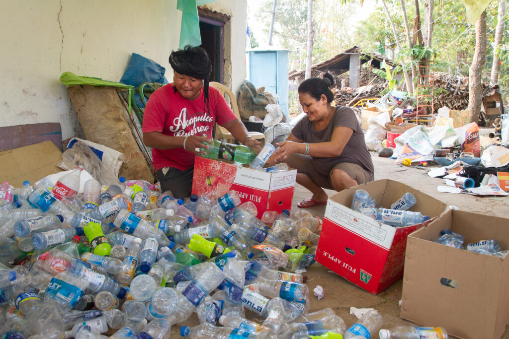 A man and woman box plastic bottles in their yard in the Indian state of Karnataka. These scrap traders are part of a circular and blue economy on land that protects the health of the ocean.     