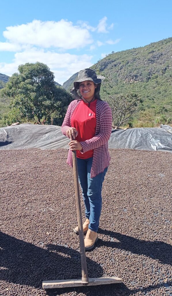 A woman stands on drying coffee in Brazil. Part of a blog post on women in agriculture. 
