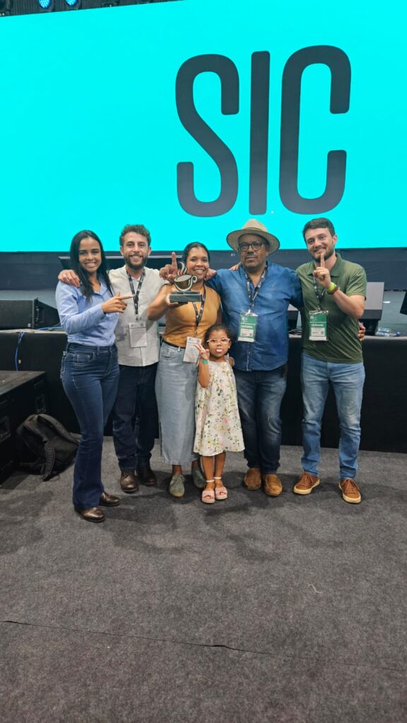 A group of people pose for a photo at a coffee event in Brazil. Part of a blog post on women in agriculture. 